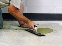 Repairing the cored holes in the concrete slab floor with fresh concrete and cleaning up the Dover home.