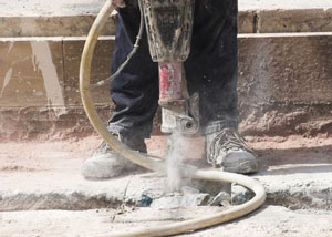 Jackhammering a slab floor in a Bear home.