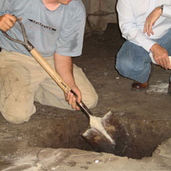 Digging a hole for the engineered fill used in a crawl space support system installation in Severn